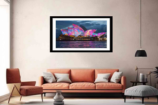 Framed artwork of a colorful Sydney Opera House in a living room.